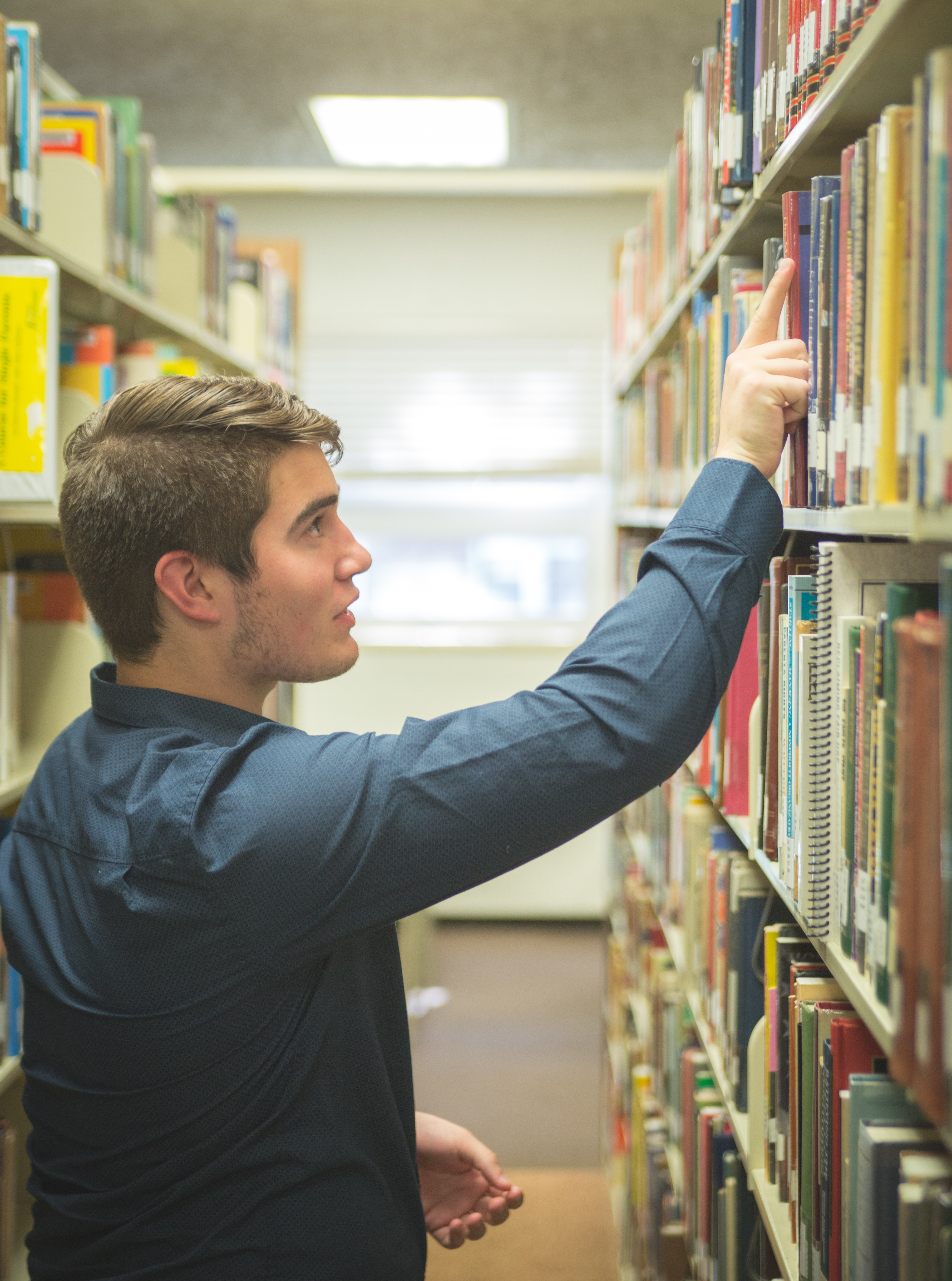 Person pulling a book from the shelves