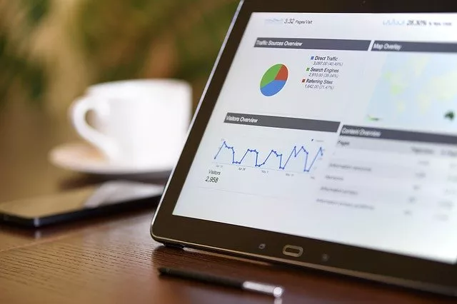 A tablet screen with graphs and charts on a table